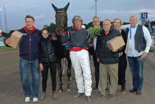 Apapmand med Anders F. Jensen omgivet af galde ejere fra Stald KTAS efter V75.sejr på Halmstad. Foto Halmstad Traet